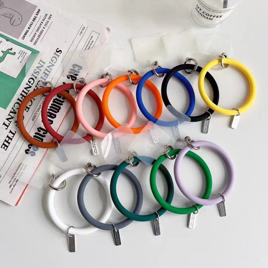 Phone case lanyard worn on wrist demonstrating adjustable silicone bracelet fit for daily carry protection